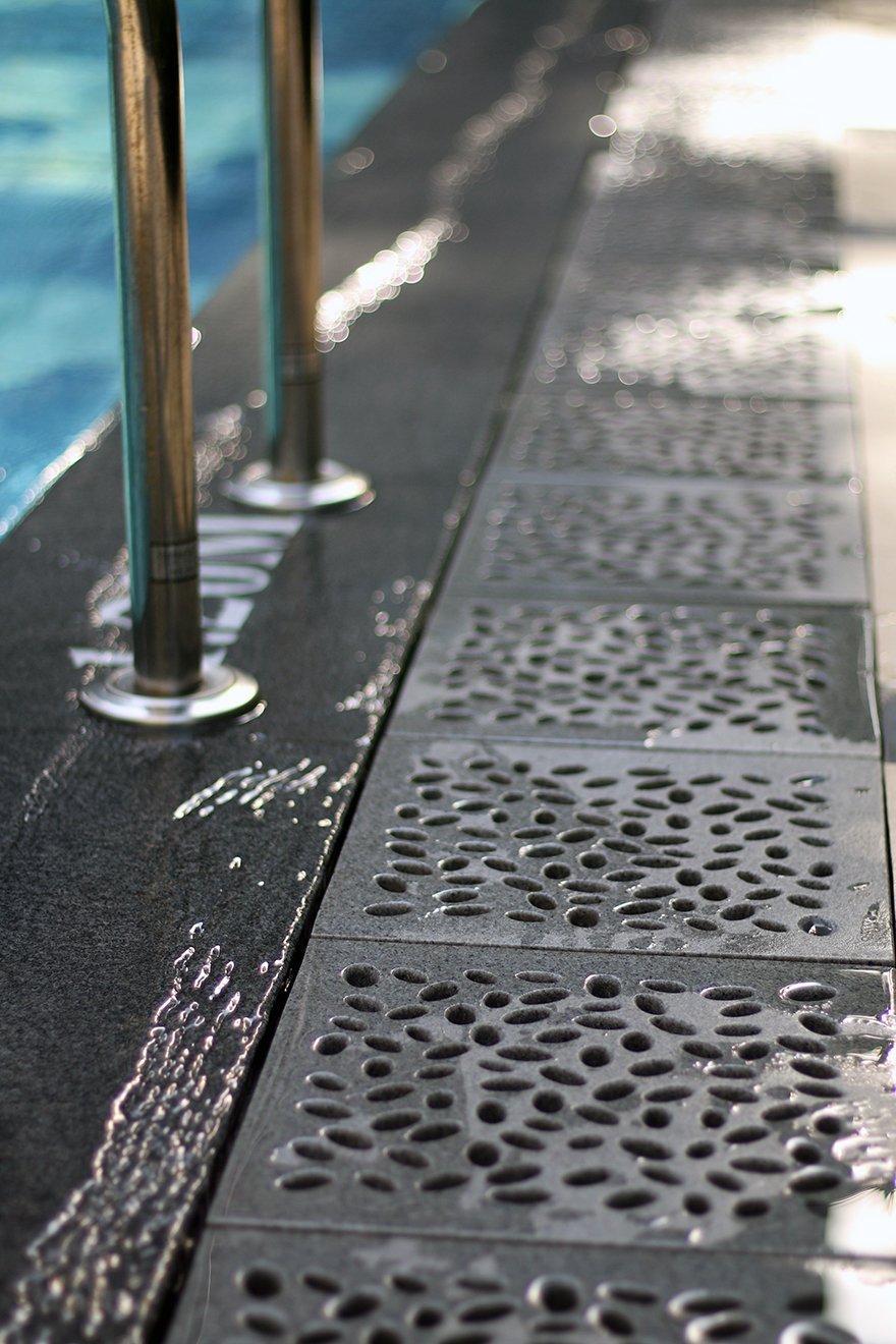 Jonite pool grate next to a pool ladder