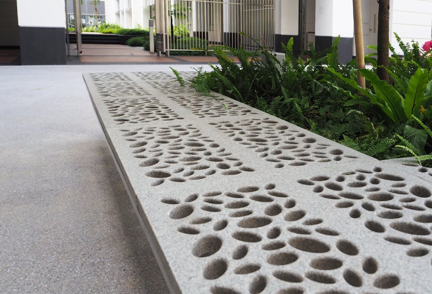 Jonite stone bench around plants outside of Yale Nus