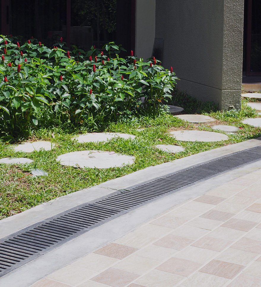 Reinforced stone trench grates in a tropical outdoor setting