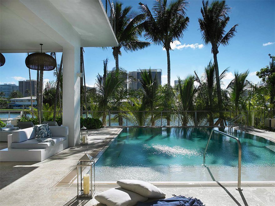 pillows, blanket, and candle next to a pool at Grand Beach Hotel