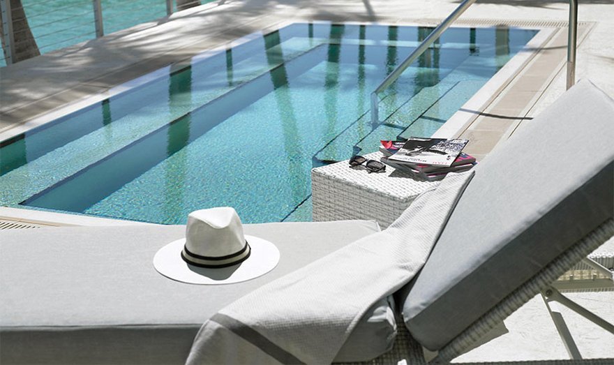 hat and towel on a lounge chair next to a plunge pool at Grand Beach Hotel