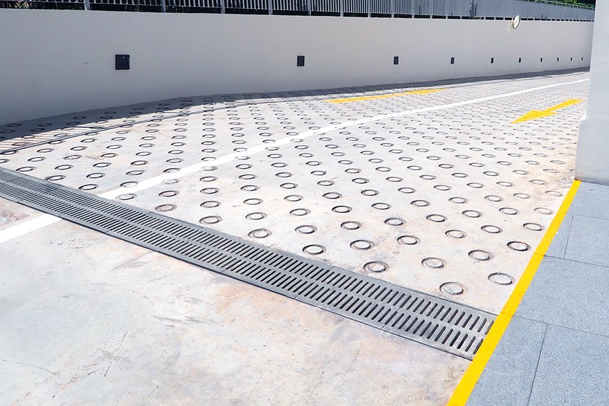 Reinforced stone trench grates that withstand vehicular loads