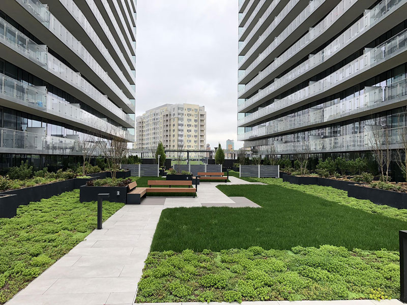 seating area with greenery in between buildings at Sky View Parc