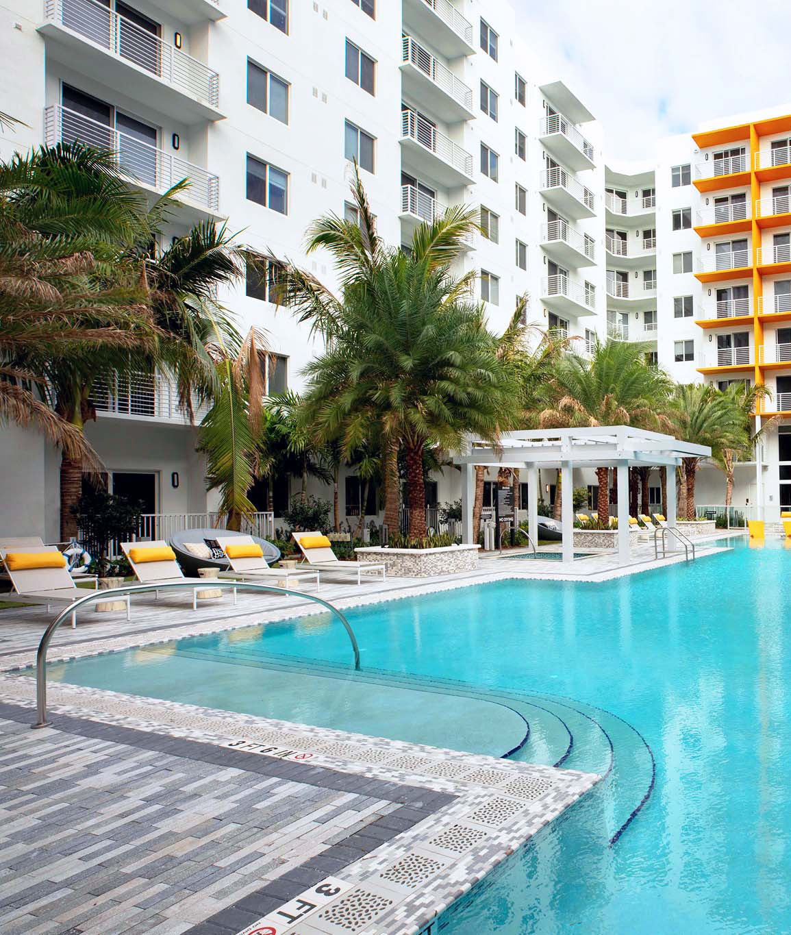 lounge chairs by the pool at Aura Boca