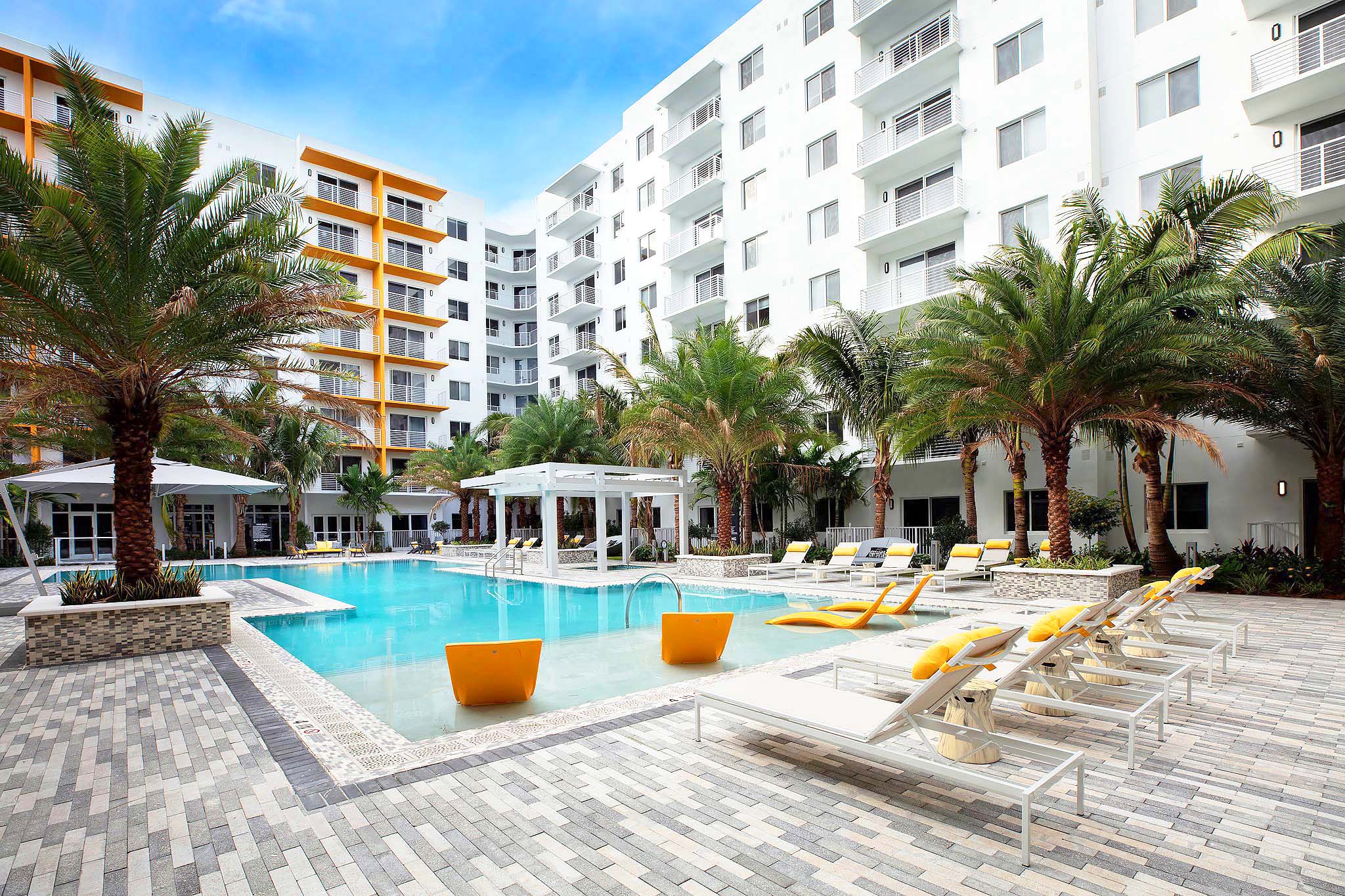 lounge chairs in and around the pool at Aura Boca