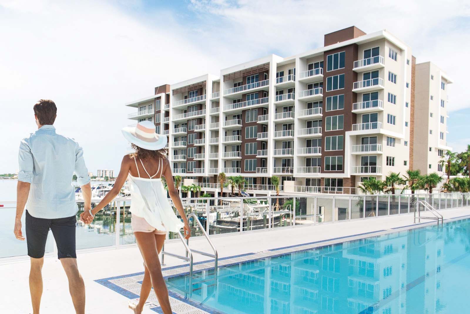 a couple holding hands and walking around the pool at Marina Bay 880