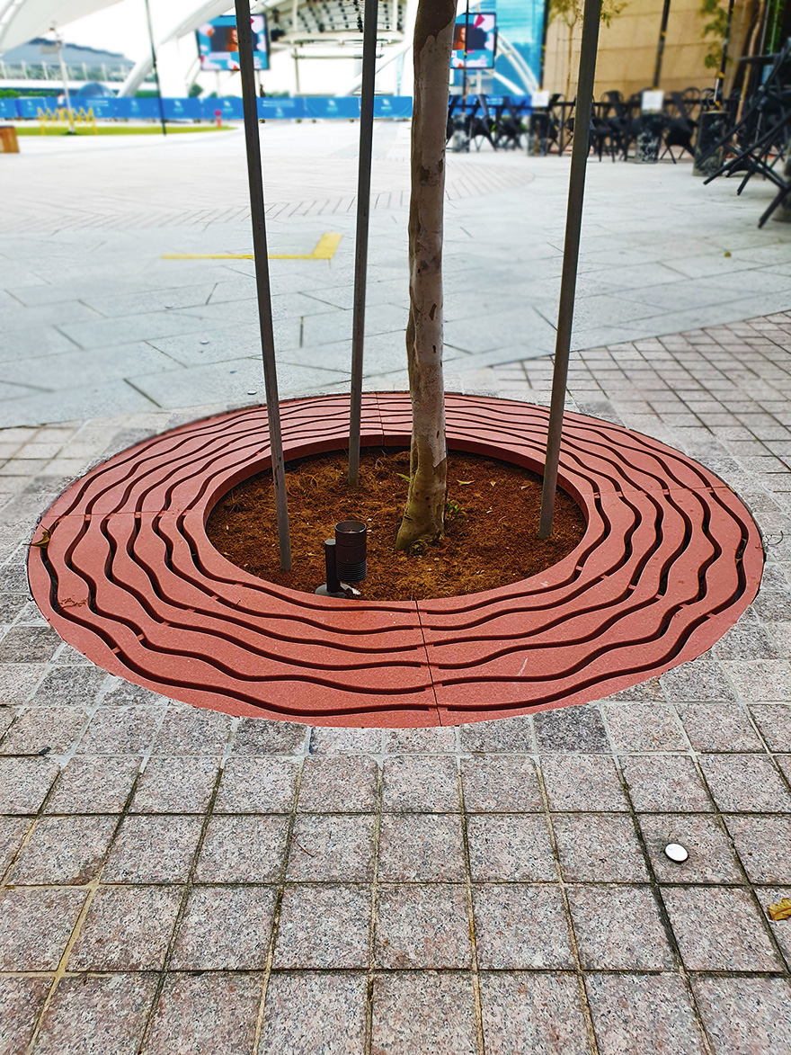 tree at the Esplanade surrounded by a custom red tree grate