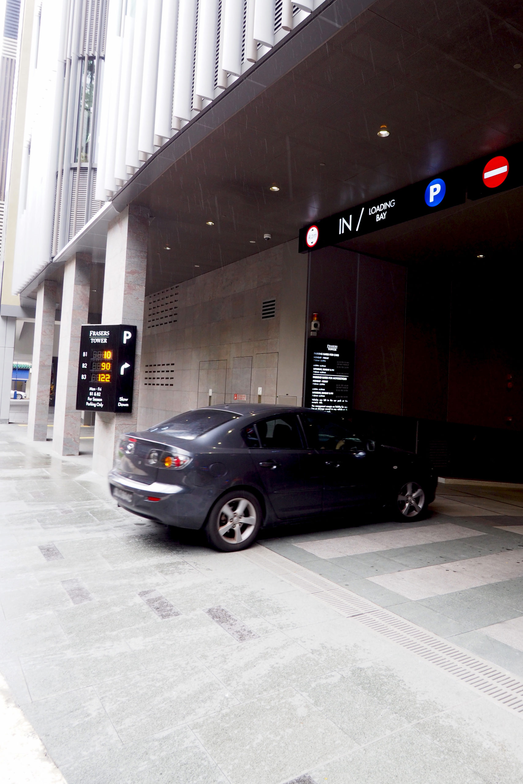 car driving over Jonite stone trench grates and into a parking garage at Frasers Tower