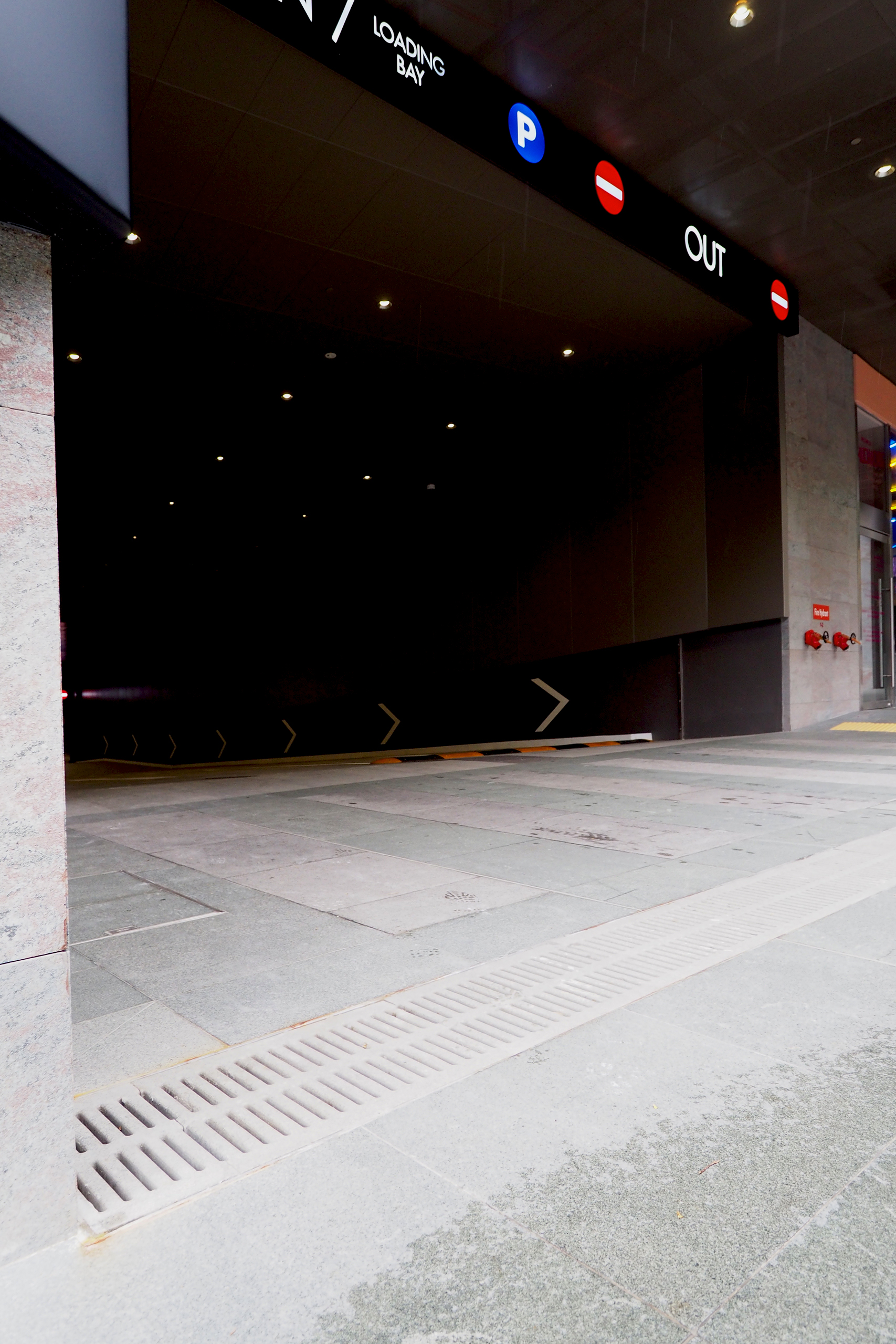 Jonite stone trench grates installed at the opening of a parking garage at Frasers Tower